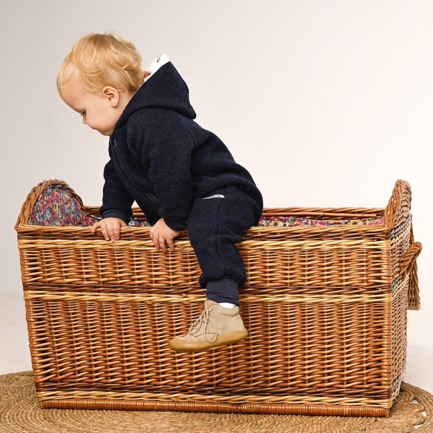 Kind in dunkelblauem Walkoverall- Möwen- Bambeeni Walkoverall für Babys & Kinder aus 100% Schurwolle und Baumwollinnenfutter