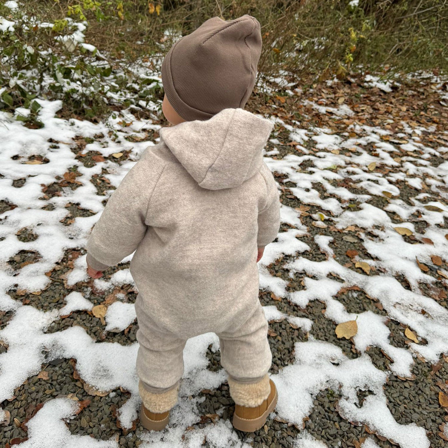 Kind in beigem Walkoverall- Bären- Schnee- Bambeeni Walkoverall fuer Babys & Kinder aus 100% Schurwolle und Baumwollinnenfutter