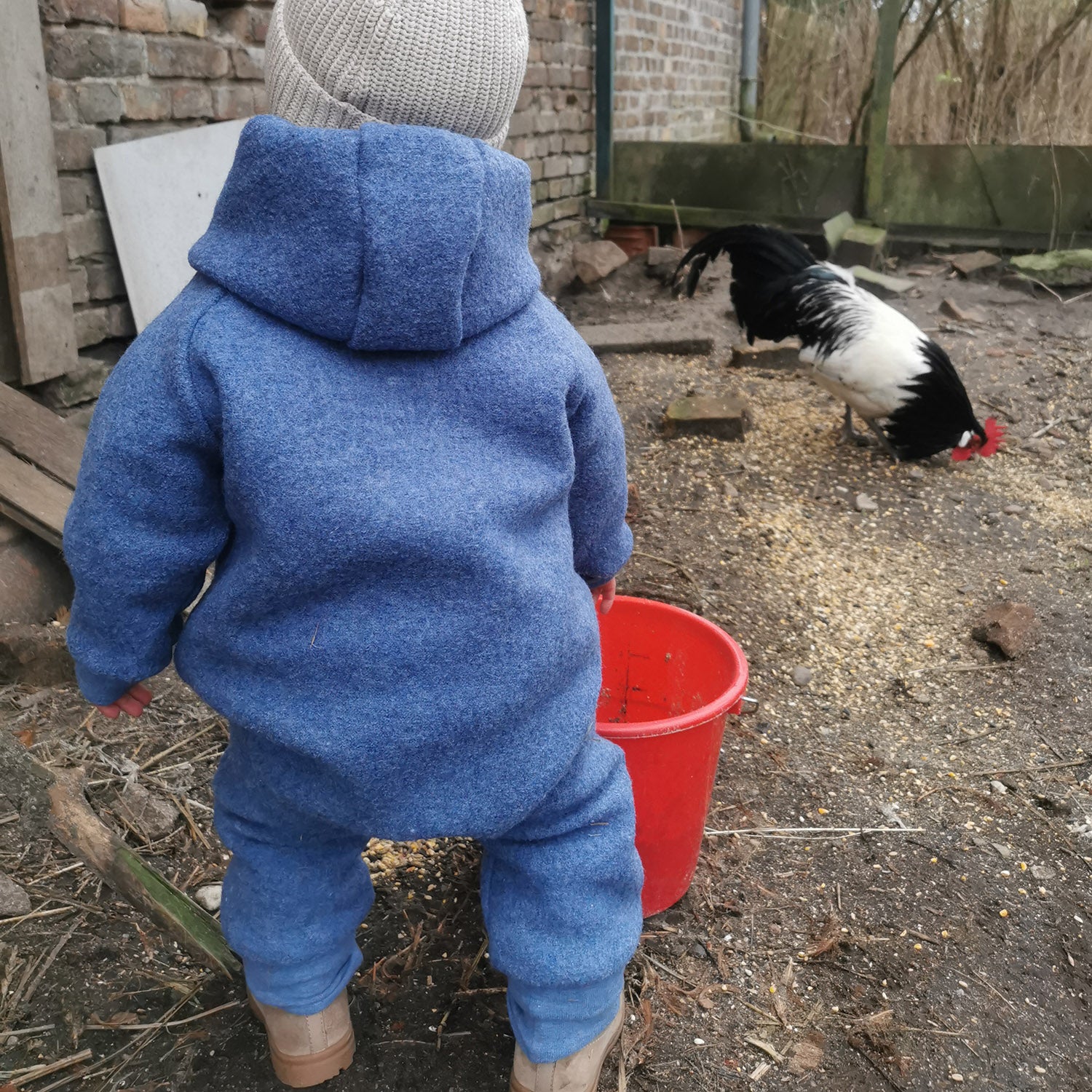 Kind in blauem Walkoverall- Paris-Bambeeni Walkoverall fuer Babys & Kinder aus 100% Schurwolle und Baumwollinnenfutter