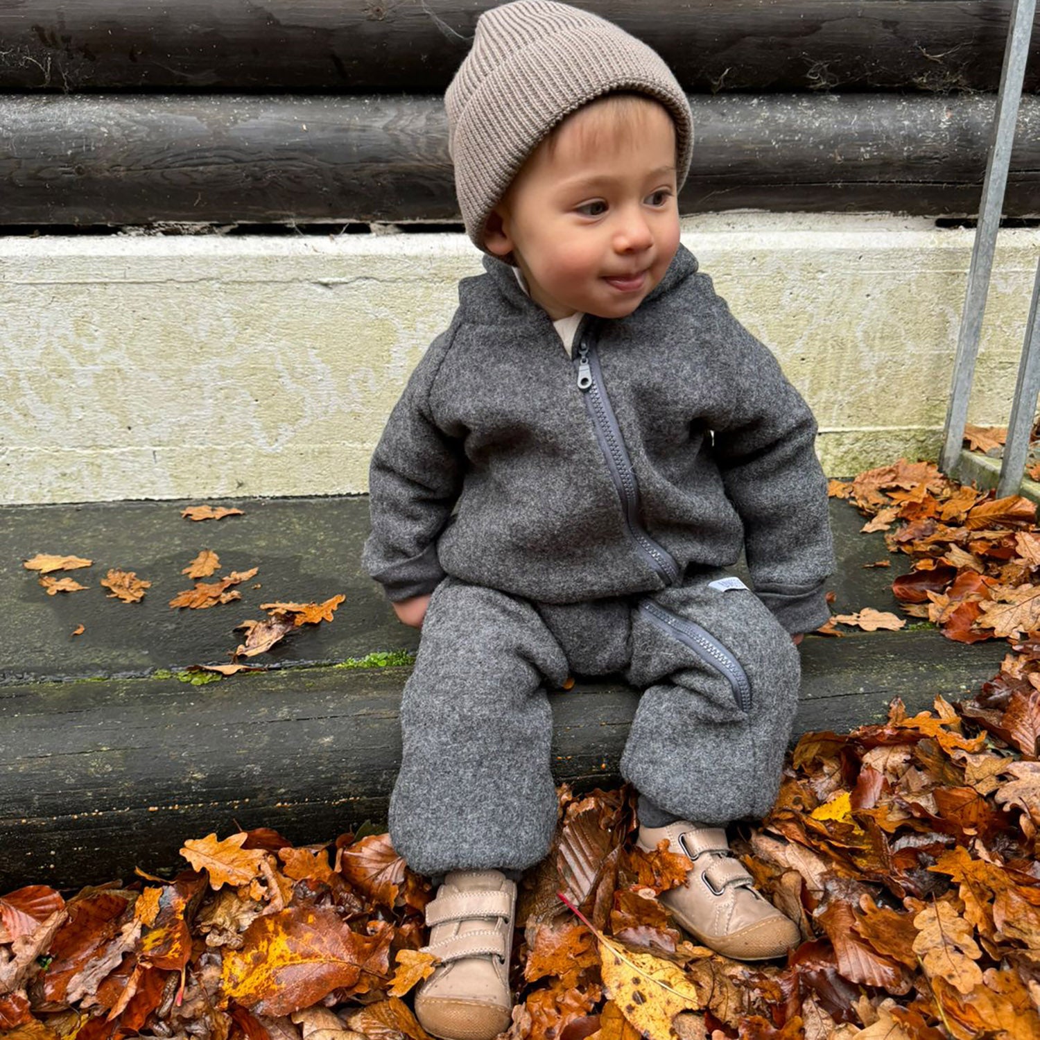 Kind in grauem Walkoverall- Sonne Mond und Regenbogen- Bambeeni Walkoverall fuer Babys & Kinder aus 100% Schurwolle und Baumwollinnenfutter