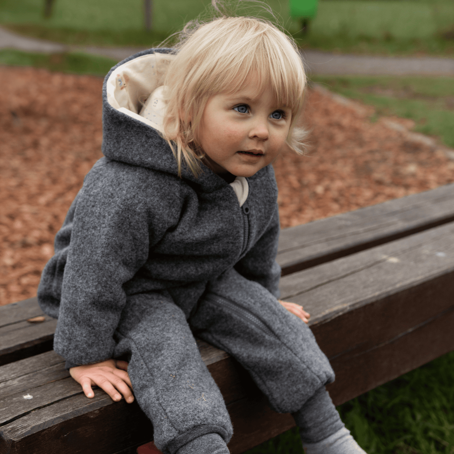 Kind in grauem Walkoverall- Sonne Mond und Regenbogen- Bambeeni Walkoverall für Babys & Kinder aus 100% Schurwolle und Baumwollinnenfutter