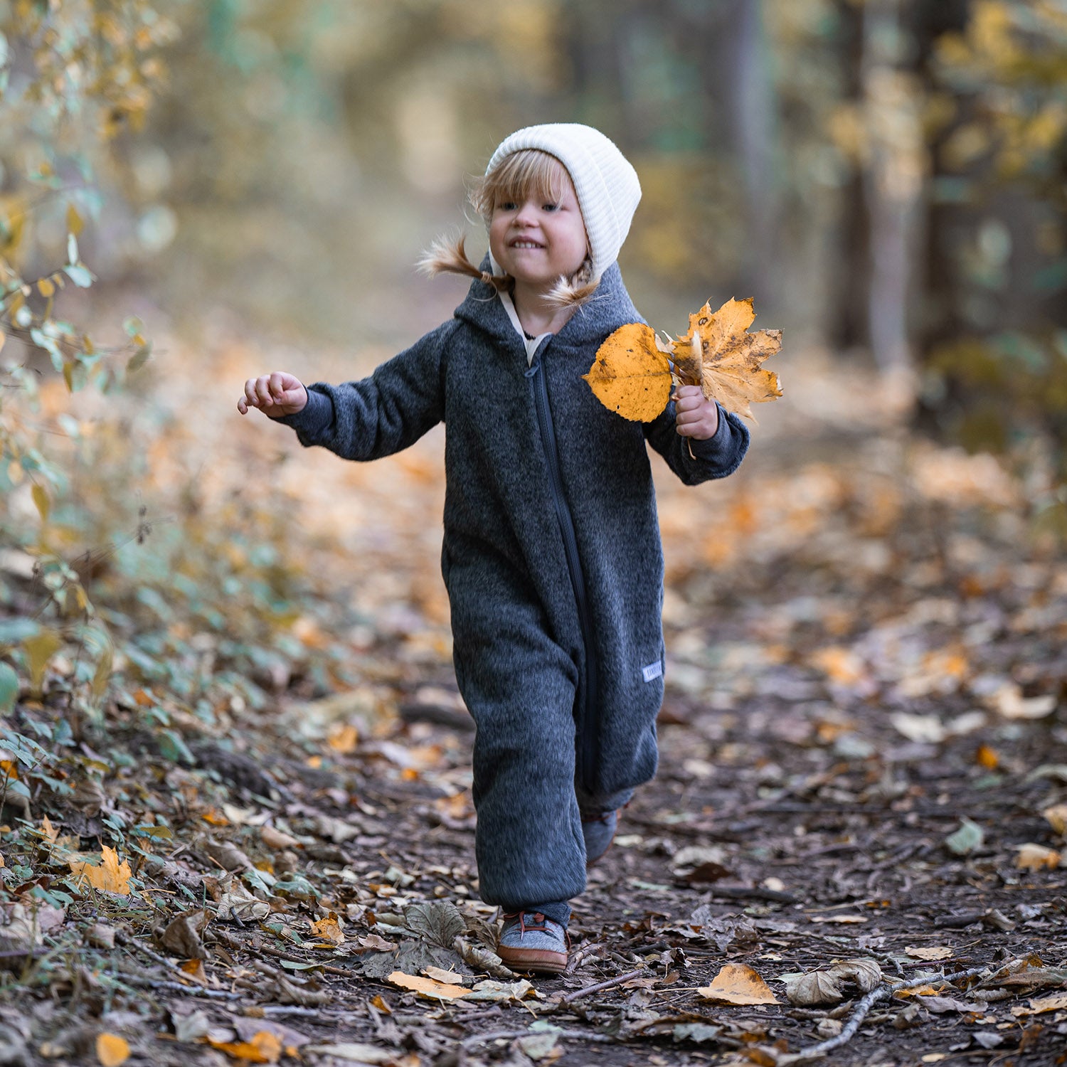Kind in grauem Walkoverall- Sonne Mond und Regenbogen- Bambeeni Walkoverall für Babys & Kinder aus 100% Schurwolle und Baumwollinnenfutter
