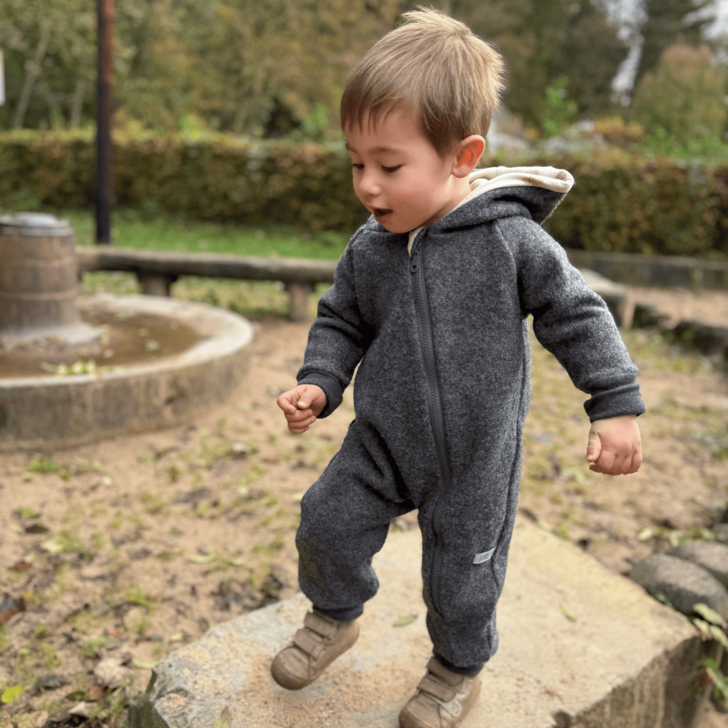 Kind in grauem Walkoverall- Sonne Mond und Regenbogen- Bambeeni Walkoverall fuer Babys & Kinder aus 100% Schurwolle und Baumwollinnenfutter
