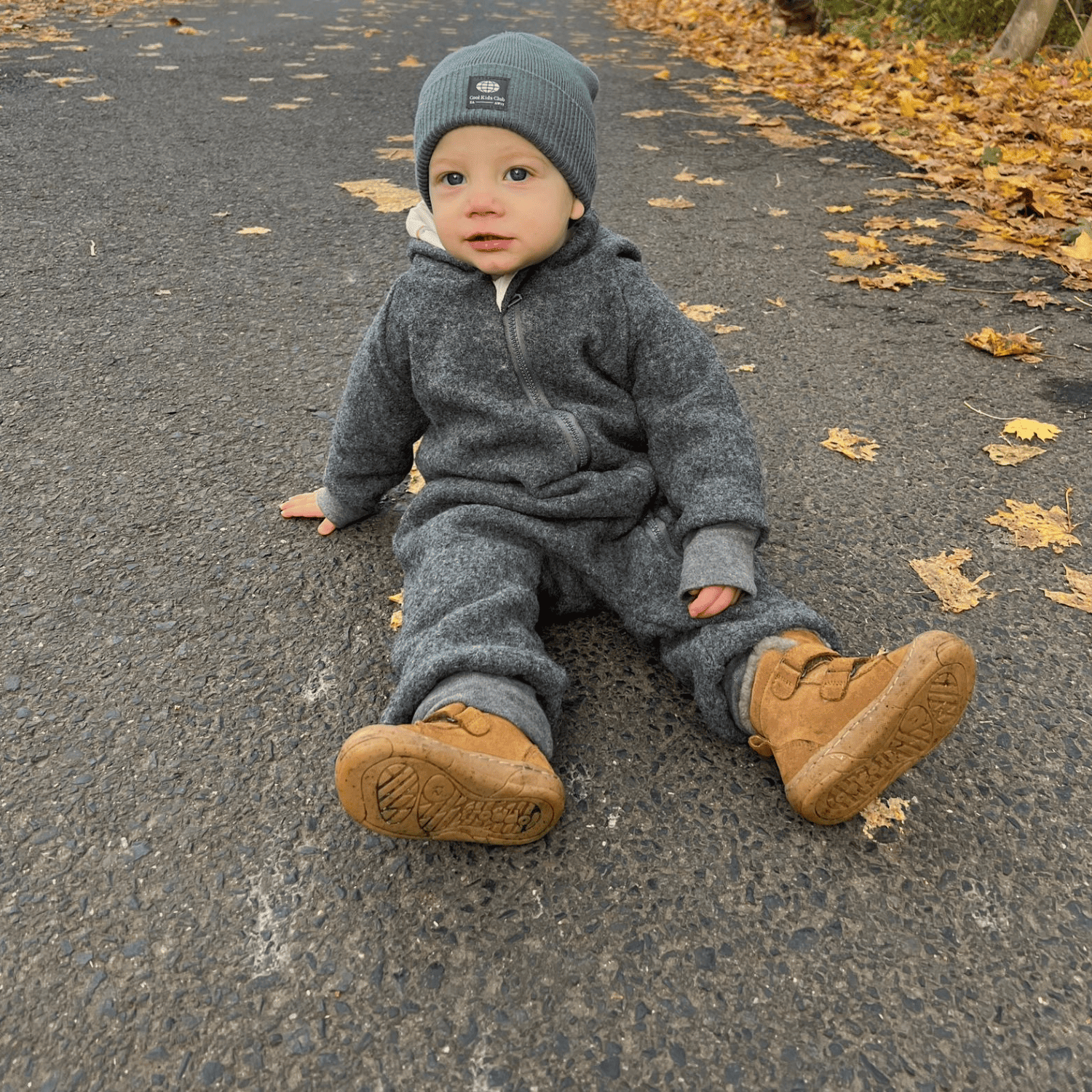 Kind in grauem Walkoverall- Sonne Mond und Regenbogen- Bambeeni Walkoverall für Babys & Kinder aus 100% Schurwolle und Baumwollinnenfutter