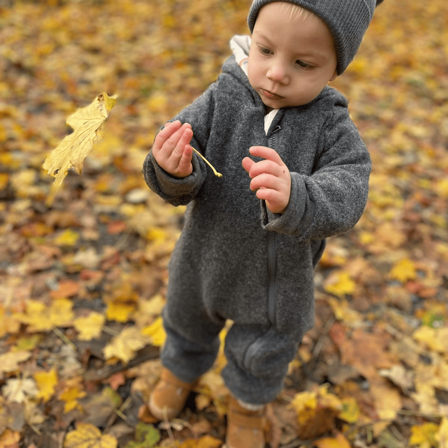 Kind in grauem Walkoverall- Sonne Mond und Regenbogen- Bambeeni Walkoverall für Babys & Kinder aus 100% Schurwolle und Baumwollinnenfutter