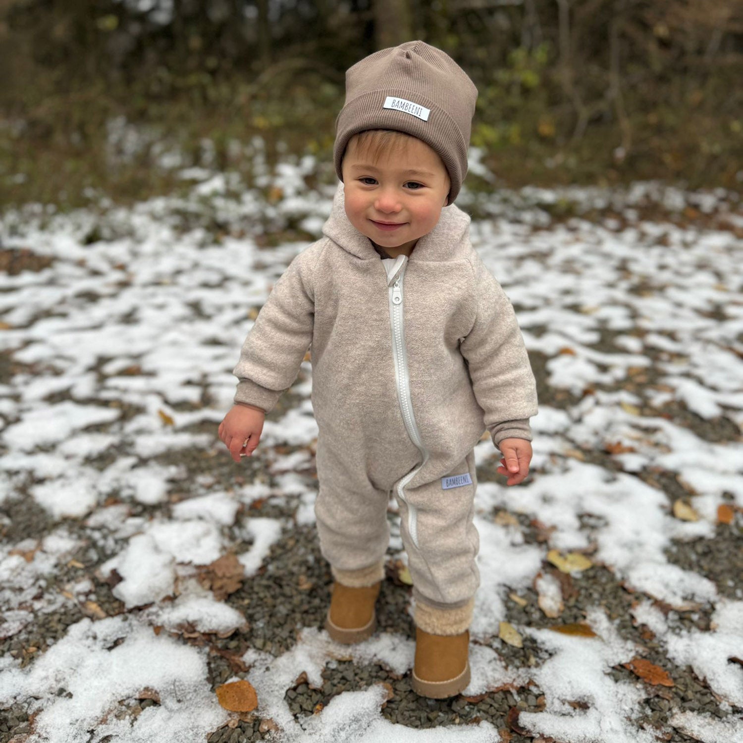 Kind in beigem Walkoverall- Bären- Schnee- Bambeeni Walkoverall fuer Babys & Kinder aus 100% Schurwolle und Baumwollinnenfutter