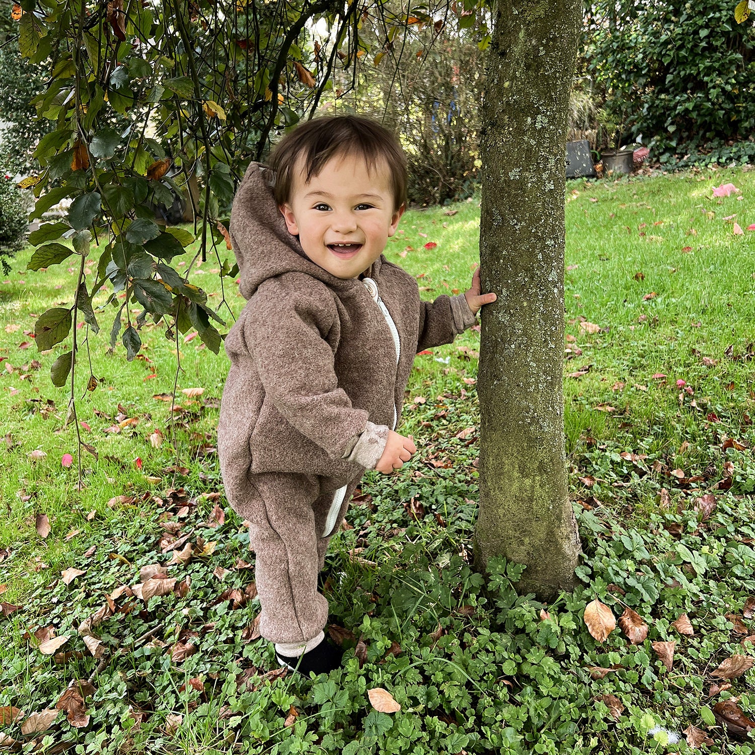 Kind in braunem Walkoverall- Regenbogen- Bambeeni Walkoverall fuer Babys & Kinder aus 100% Schurwolle und Baumwollinnenfutter