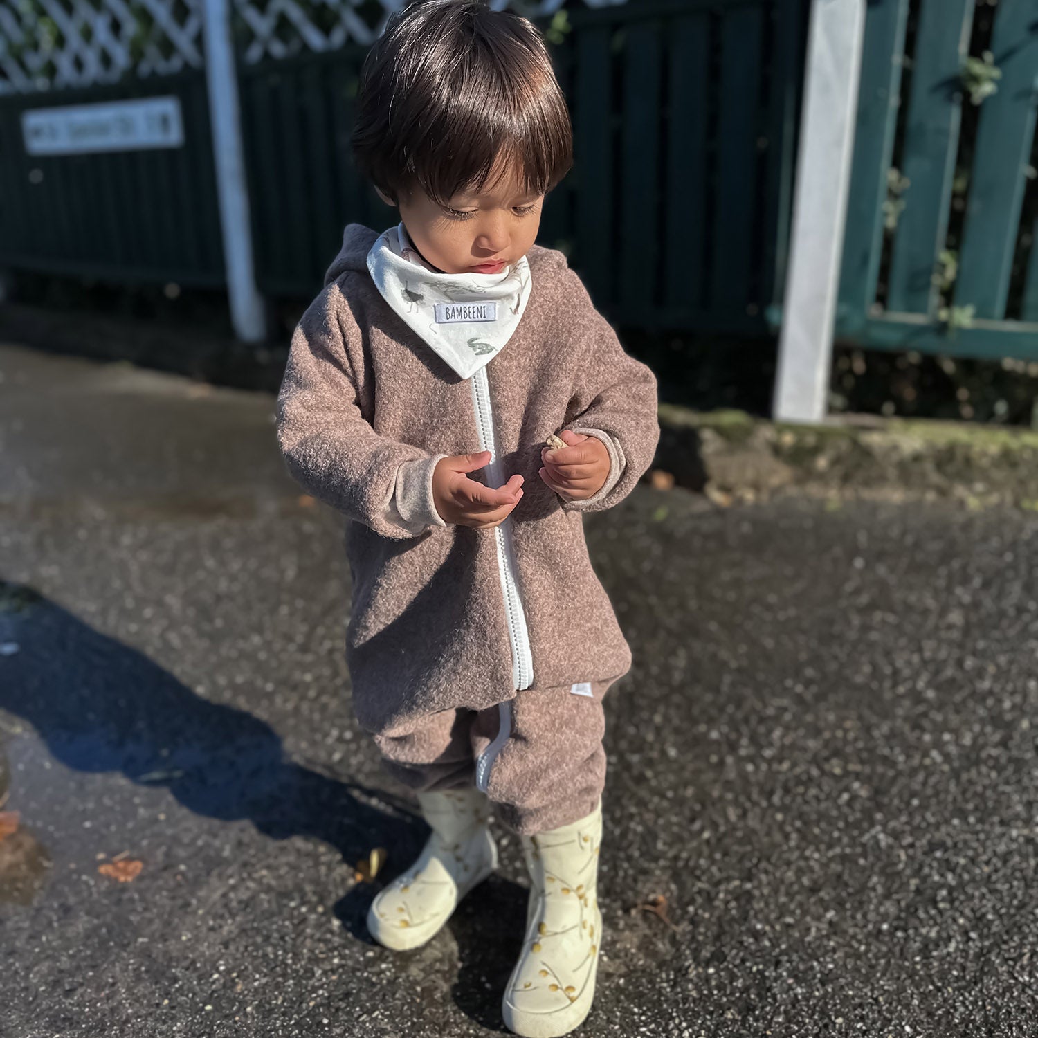 Kind in braunem Walkoverall- Regenbogen- Bambeeni Walkoverall fuer Babys & Kinder aus 100% Schurwolle und Baumwollinnenfutter