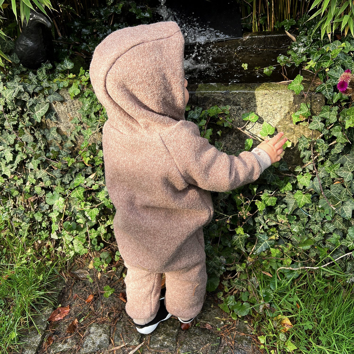 Kind in braunem Walkoverall- Regenbogen- Bambeeni Walkoverall fuer Babys & Kinder aus 100% Schurwolle und Baumwollinnenfutter