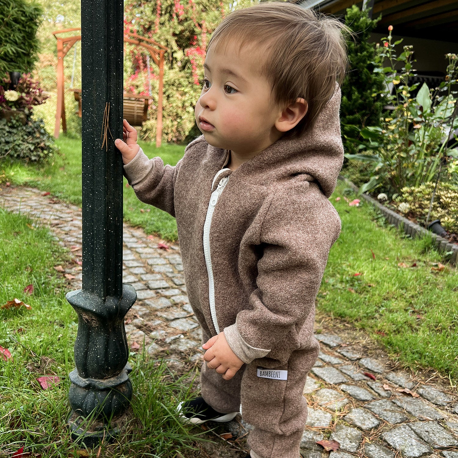 Kind in braunem Walkoverall- Regenbogen- Bambeeni Walkoverall fuer Babys & Kinder aus 100% Schurwolle und Baumwollinnenfutter